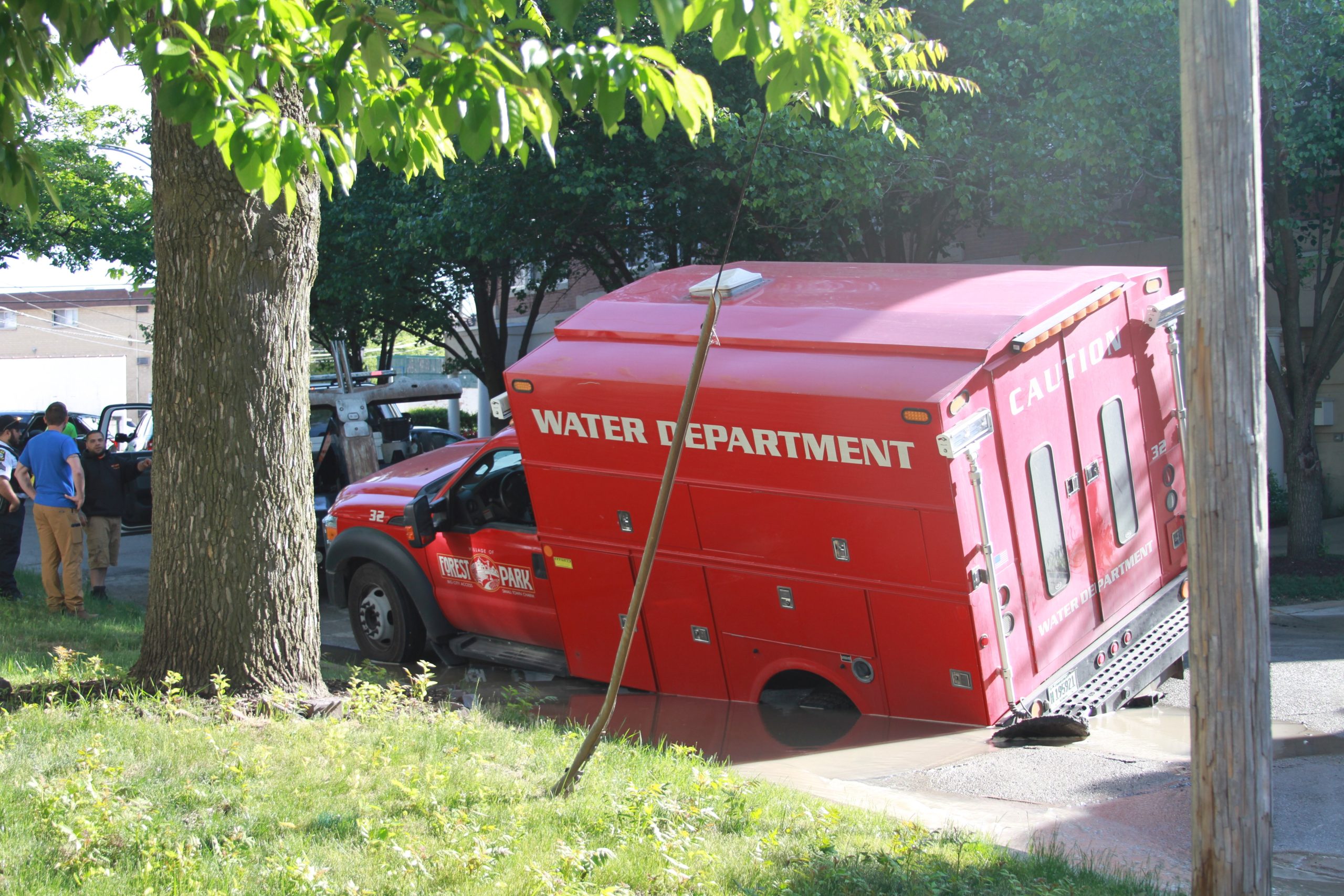 Public works truck sinks as street gives way with water main break